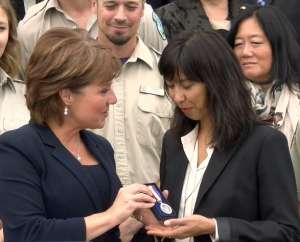 Phare’s fiance Kimi Hawkes accepting the medal from Premier Christy Clark